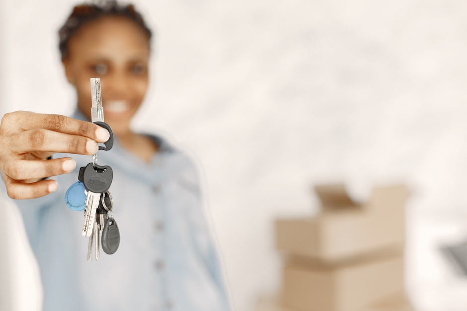 A woman with a warm smile, slightly blurred in the background, extends her arm towards the camera while holding a set of keys in her hand. The keys include various types such as standard metal keys, a